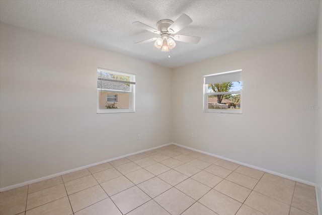 unfurnished room with a wealth of natural light, baseboards, and ceiling fan