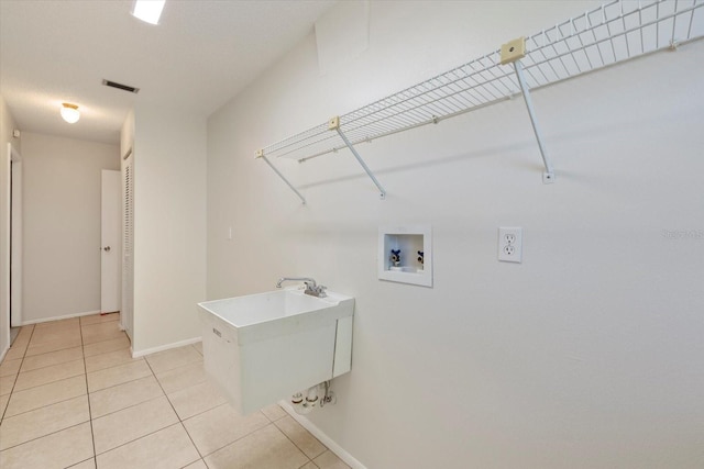 laundry room with visible vents, light tile patterned flooring, baseboards, hookup for a washing machine, and laundry area