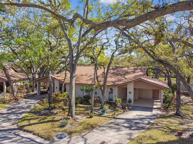 view of front of home featuring a carport, stucco siding, and concrete driveway