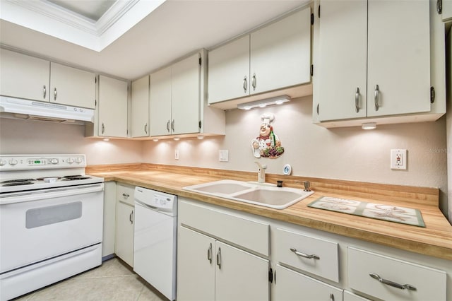 kitchen with ornamental molding, a sink, under cabinet range hood, white appliances, and light tile patterned flooring