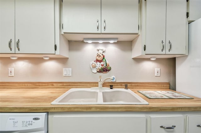 kitchen featuring washer / clothes dryer, light countertops, and a sink