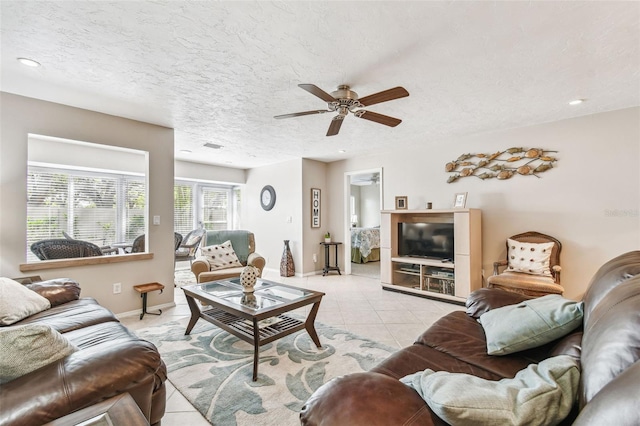 living area featuring light tile patterned floors, baseboards, recessed lighting, ceiling fan, and a textured ceiling