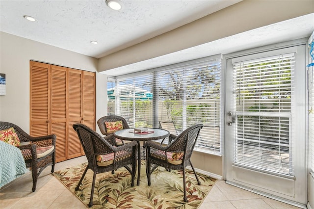 dining room with light tile patterned floors, a textured ceiling, a healthy amount of sunlight, and recessed lighting