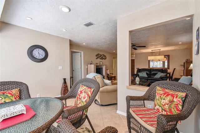 living room with visible vents, a ceiling fan, a textured ceiling, recessed lighting, and light tile patterned floors