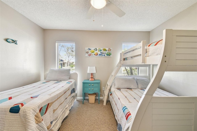 bedroom with multiple windows, a textured ceiling, ceiling fan, and carpet flooring