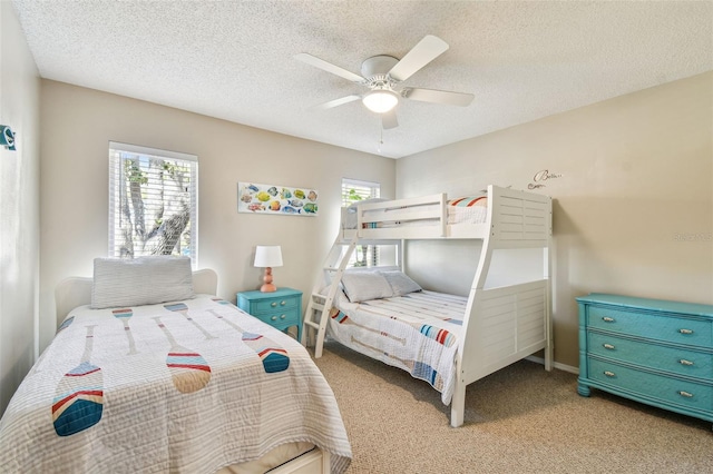 carpeted bedroom featuring multiple windows, a textured ceiling, and ceiling fan