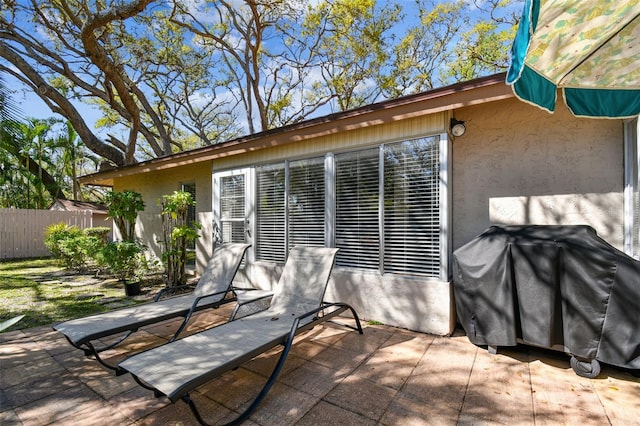 view of patio featuring area for grilling and fence