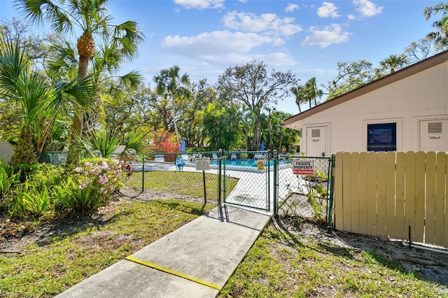 view of yard featuring fence, a community pool, and a gate