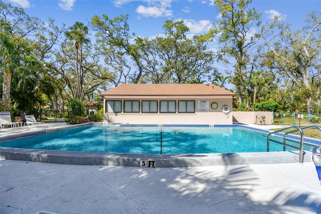 community pool featuring a patio and fence