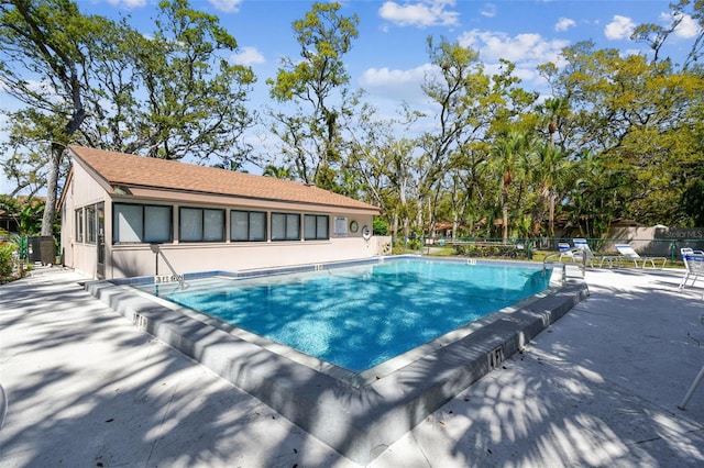 community pool featuring a patio area and fence