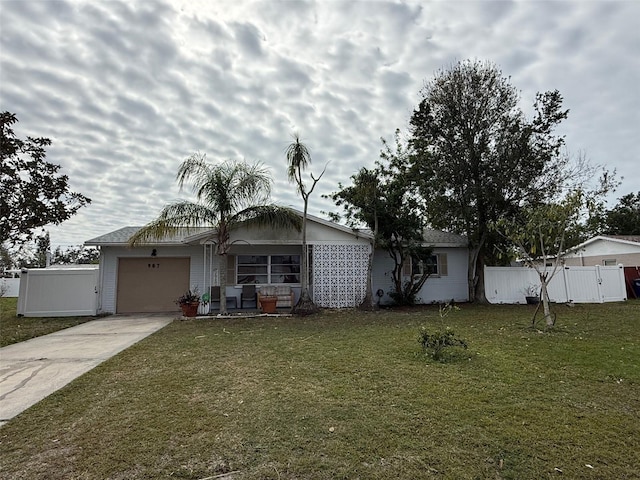 view of front of home featuring a garage, concrete driveway, a front lawn, and fence