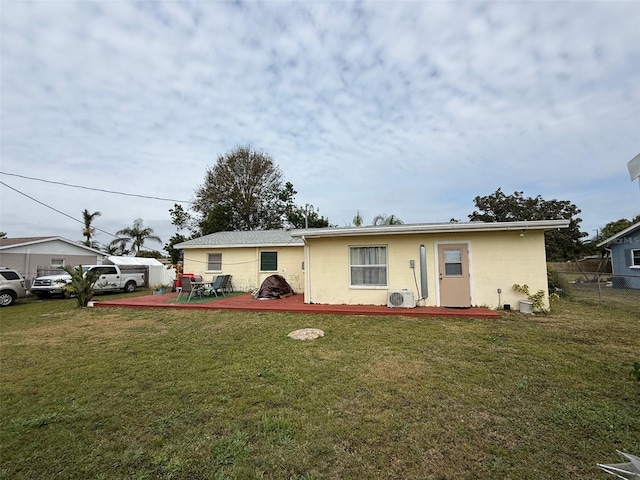 view of front of property featuring a deck, ac unit, a front yard, and fence