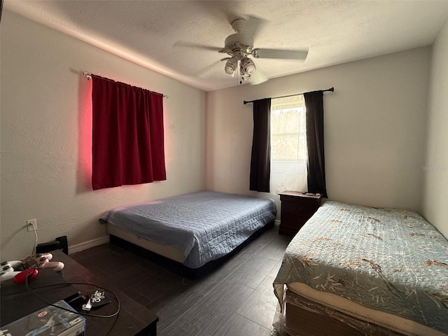 bedroom with a textured ceiling, ceiling fan, and wood finished floors