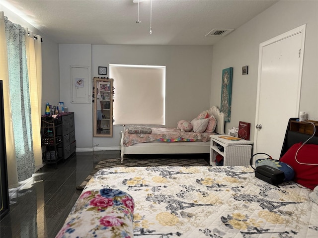 bedroom featuring visible vents, a textured ceiling, and baseboards