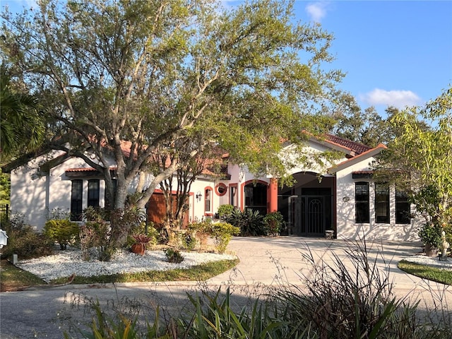 mediterranean / spanish-style home featuring stucco siding and a tiled roof