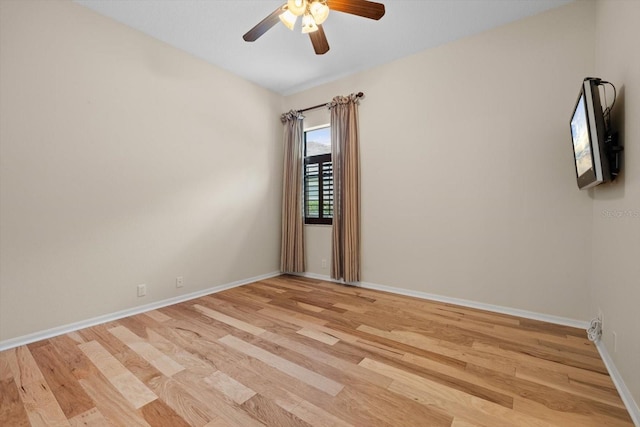 empty room with a ceiling fan, baseboards, and light wood-type flooring