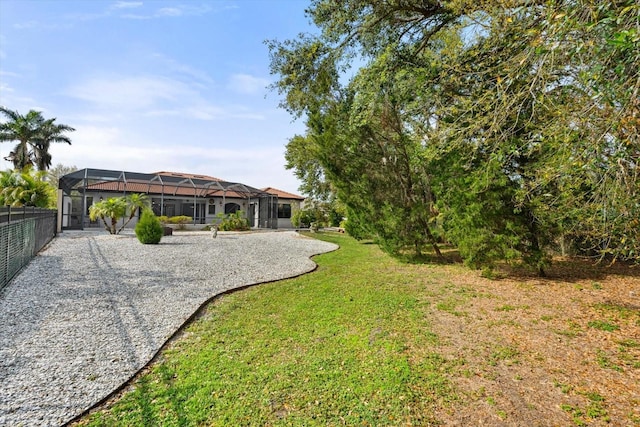 view of yard featuring glass enclosure and fence