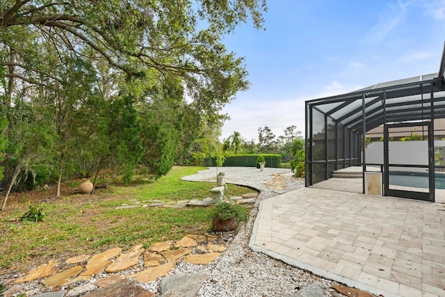 view of yard with glass enclosure and a patio