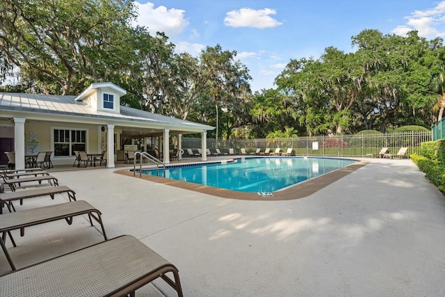 pool with a patio and fence