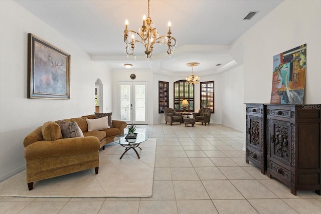 living room with light tile patterned floors, visible vents, an inviting chandelier, arched walkways, and french doors