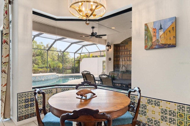 tiled dining space featuring ceiling fan and a sunroom