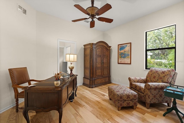 office featuring light wood finished floors, visible vents, ceiling fan, and baseboards