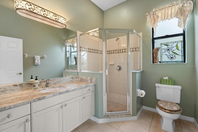 full bath featuring tile patterned flooring, baseboards, toilet, a stall shower, and vanity