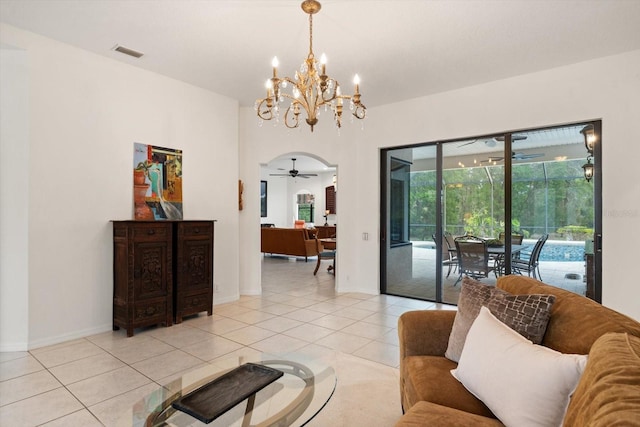 living room with light tile patterned flooring, visible vents, ceiling fan with notable chandelier, and baseboards