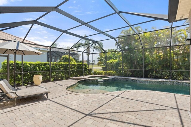 view of pool featuring a patio area, a lanai, and a pool with connected hot tub