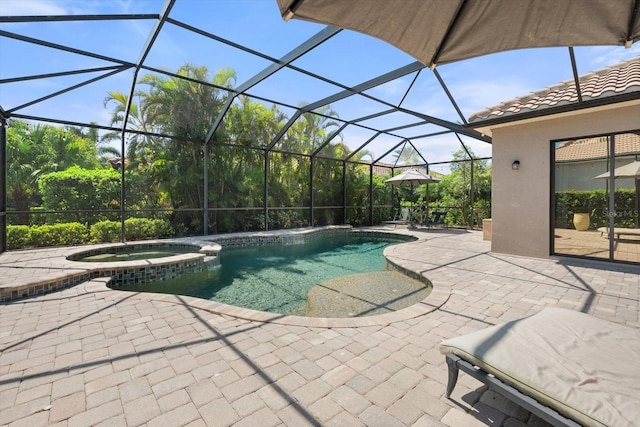 view of pool featuring a patio area, glass enclosure, and a pool with connected hot tub