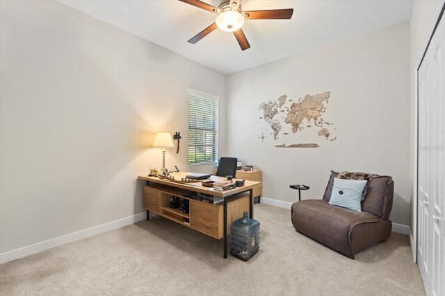 office featuring light colored carpet, baseboards, and ceiling fan