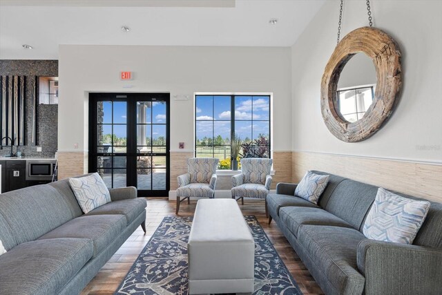 living room featuring wood finished floors, french doors, and wainscoting