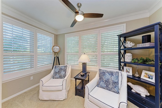 living area featuring ornamental molding, baseboards, ceiling fan, and carpet floors