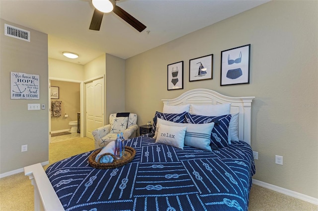 carpeted bedroom with visible vents, ceiling fan, ensuite bathroom, and baseboards