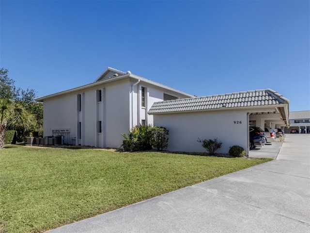 view of property exterior featuring a tiled roof, central AC unit, stucco siding, a lawn, and driveway