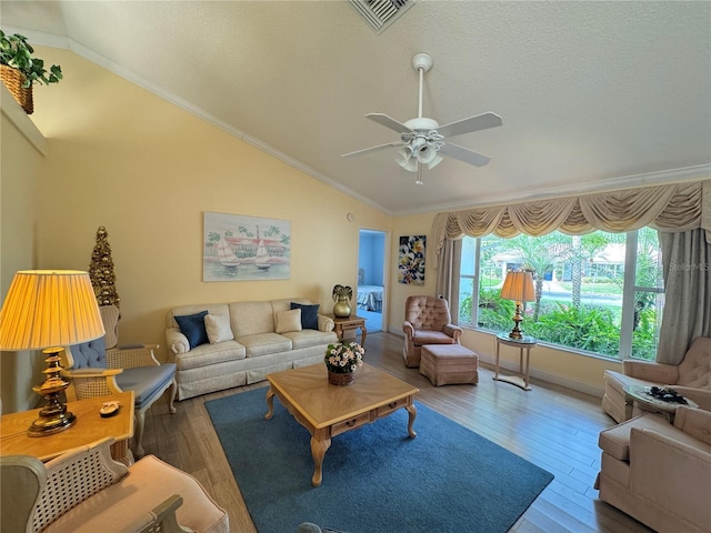 living room with a ceiling fan, wood finished floors, visible vents, lofted ceiling, and crown molding