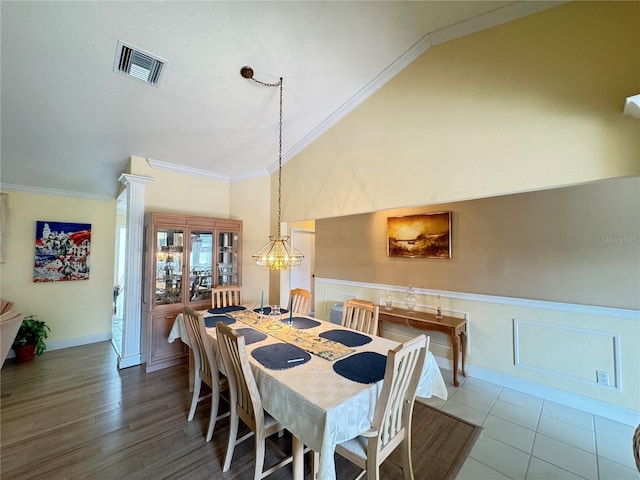 dining room with visible vents, high vaulted ceiling, a wainscoted wall, and crown molding