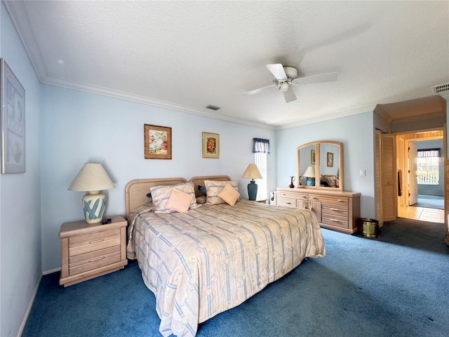 bedroom with ornamental molding, a ceiling fan, carpet floors, and a textured ceiling