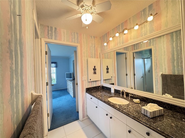 bathroom with wallpapered walls, a textured ceiling, tile patterned flooring, ceiling fan, and vanity