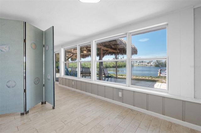 unfurnished sunroom with a water view