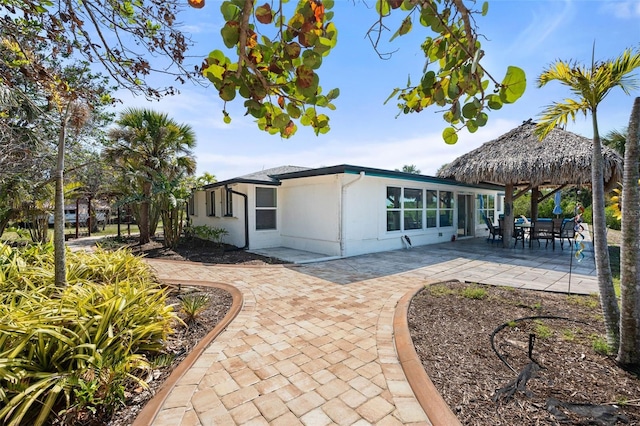 rear view of house with a patio area, stucco siding, and a gazebo