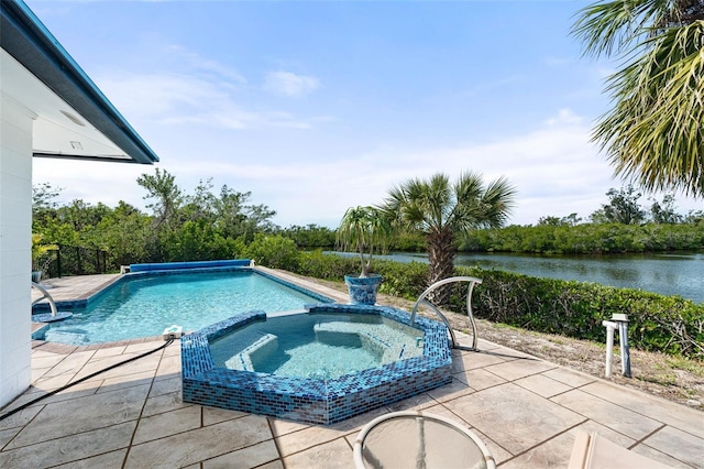 view of swimming pool with a pool with connected hot tub, a patio, and a water view