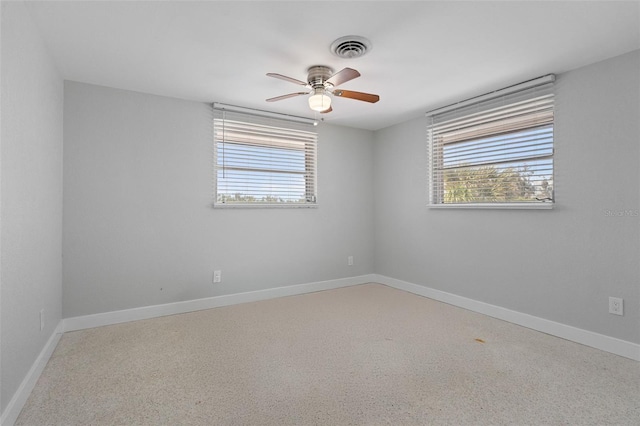 empty room with plenty of natural light, baseboards, visible vents, and ceiling fan