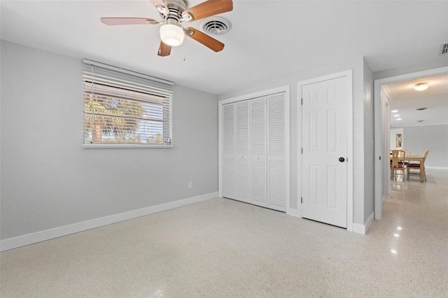 unfurnished bedroom with a ceiling fan, visible vents, speckled floor, baseboards, and multiple closets