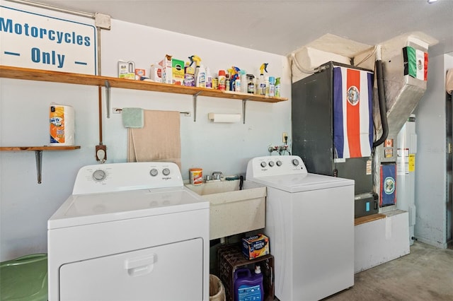 clothes washing area with washer and clothes dryer, laundry area, and a sink