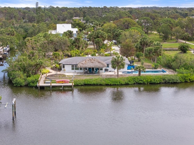 drone / aerial view with a wooded view and a water view