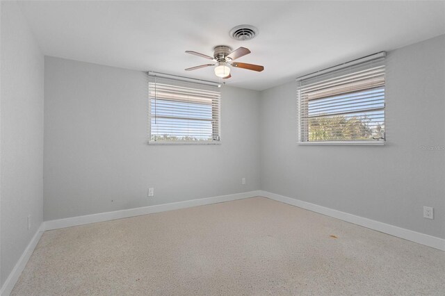 spare room with plenty of natural light, visible vents, a ceiling fan, and baseboards