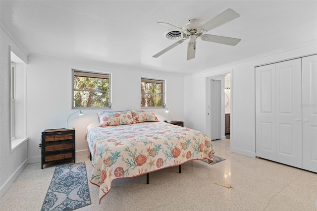 bedroom featuring a ceiling fan, a closet, speckled floor, baseboards, and ornamental molding