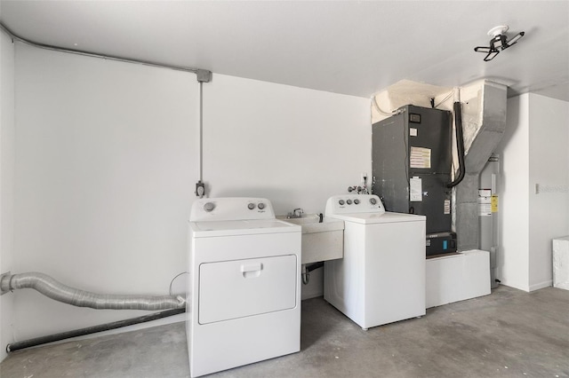washroom with a sink, electric water heater, laundry area, and independent washer and dryer
