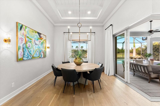 dining space with light wood finished floors, baseboards, a tray ceiling, recessed lighting, and ceiling fan with notable chandelier